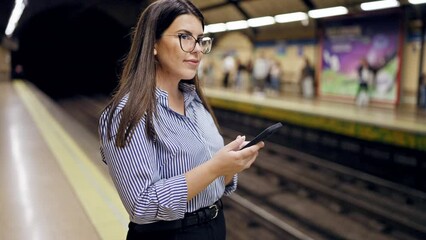 Sticker - Young beautiful hispanic woman waiting for the subway using smartphone in subway station of Madrid