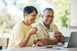 © Charlize D/peopleimages.com - Laptop, laughing and senior couple streaming a comedy show online, internet or from a subscription service on the web. Morning, coffee and elderly people happy together in a home watching funny movie