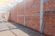 © Sumeth - Brick building wall. Installing bricks on construction site.
