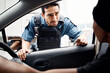 © M Einero/peopleimages.com - Talking, drivers license or policeman in city to check info for law enforcement, protection or street safety. Questions, traffic stop or Asian cop on security patrol for road block or crime justice