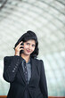 © Image Smith - Indian business woman using mobile phone.