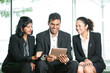 © Image Smith - Indian Business people looking at a digital tablet.