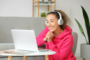 Sticker - Mature woman with laptop and headphones at home