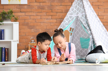 Cute little children with adventure book at home