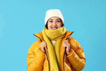 Sticker - Young Asian woman in winter clothes on blue background