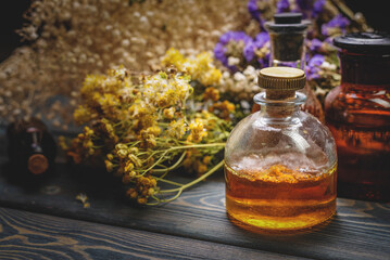 Wall Mural - Herbal medicine concept background. Dry natural ingredients and remedy bottle on the wooden table background. Top view. Witchcraft.