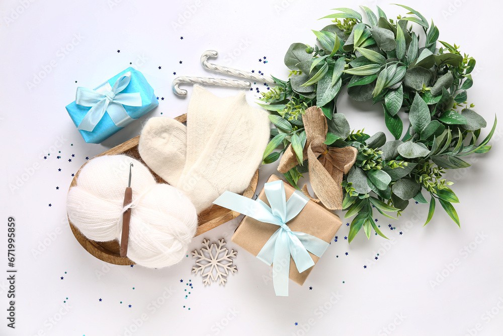 Beautiful composition with warm socks and Christmas decor on white background