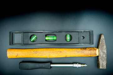 screwdriver hammer and spirit level isolated on black background