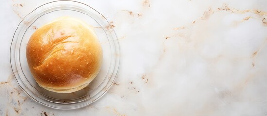 Poster - Freshly baked bun placed on a glass plate with a background of marble presented in a flat lay