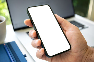 Male hand holding phone with isolated screen on laptop background