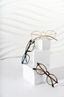 © Dina Photo Stories - Trendy eyeglasses in plastic and metallic frame on a white background. Close up. Sunglasses and spectacles sale concept. Optic shop promotion banner. Eyewear fashion. Minimalism. Vertical
