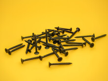 Black Powder Coated Dry Wall Screws Isolated On A Plain Background