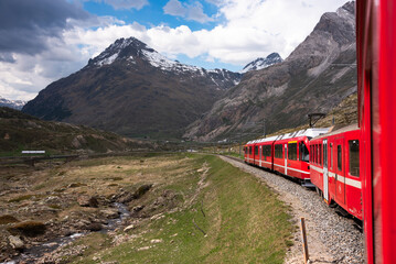 Wall Mural - Red train going in beautiful landscape in Switzerland