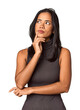 Young Filipina with long black hair in studio looking sideways with doubtful and skeptical expression.
