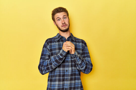 Young Caucasian man on a yellow studio background scared and afraid.