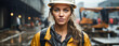 Young female European construction worker / engineer with hard hat in the background a construction site, blonde hair