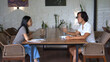 © SERGEI - Asian busy people work together cowork cafe. Colleague girl man discuss job Asia. Teamwork meet talk. Coworker person train team conference. Guy boss sit study desk. Thai employee group pen start up.