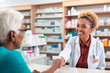 Elderly lady buys medication in the pharmacy
