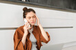 © Mix and Match Studio - Woman booking appointment with GP over the phone, has headache or migraine, calling in sick, sits on floor at home