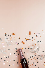 Concept of party celebration, New Year. Champagne bottle and glasses with confetti and gold stars. Top view, copy space, flatlay