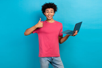 Sticker - Photo of satisfied guy wear pink trendy clothes demonstrate thumb up recommend buy modern technology isolated on blue color background