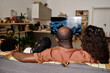 © AnnaStills - Black family watching recorded speech of Martin Luther King Jr on tv, view from the back