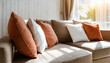 Close up of fabric sofa with white and terra cotta pillows. French country home interior design of modern living room.
