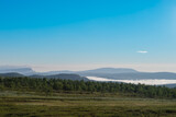 Fototapeta Na ścianę - Early in the morning up in the mountains of Tänndalen in Sweden. A beautiful blue sky and morning mist still lingering down in the valley.
