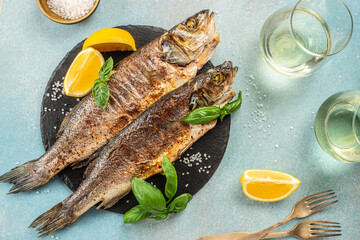 Wall Mural - delicious grilled seabass fish with lemon and spices with white wine. banner, menu, recipe copy space, top view