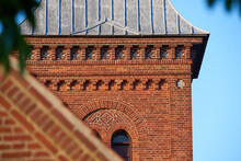 Closeup Of A Red Face Brick Church Steeple Against A Blue Sky. Tall Infrastructure And Tower Used To Symbolise Faith And Christian Or Catholic Devotion. Architecture Of A Built Structure Outside