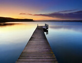 Fototapeta Perspektywa 3d - Tranquil Lakeside Pier at Sunrise