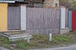© butus - part of a fence wall made of white bricks and brown iron on a city street