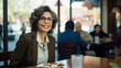 © Kristian - Latina Woman Female Sitting in Restaurant Cafe at Lunch Looking at Camera, Smiling with Glasses, Middle Aged Business Woman