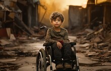 A Sad Young Boy In A Wheelchair Amid A Devastated City, A Poignant Symbol Of Suffering And Resilience