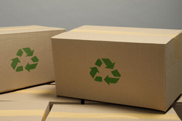 Cardboard boxes with recycle sign stamps on grey background