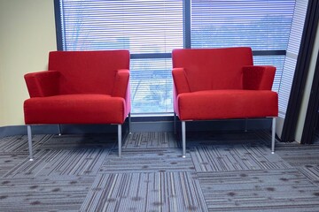 Two red chairs in a office building