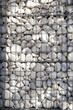 A bunch of white polished pebbles behind a metal grid