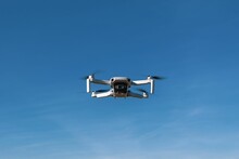The Small Black And White Drone Is Flying In The Sky