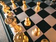 Classic wooden chess board with golden chess pieces