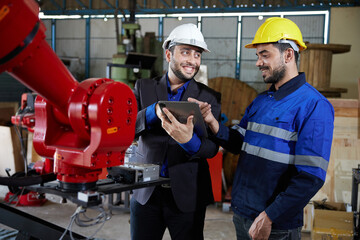 worker or engineer and businessman working on tablet in robot factory