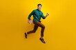 © deagreez - Photo of cheerful nice man wear stylish clothes run hold netbook macbook isolated on yellow color background