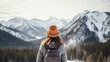 backside of young woman looking at snowy mountains