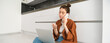 © Mix and Match Studio - Woman looking bored and unamused while sitting on floor and listening to conversation, has laptop on laps, waiting on line, making phone call