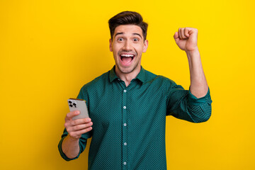 Poster - Photo of crazy cheerful glad man wear trendy clothes raise hand fist rejoice success luck isolated on yellow color background