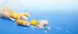 Pills spilling out of a bottle on a blue surface. Copyspace, place for text.