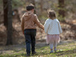 little boy and girl walk holding hands