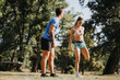 © qunica.com - A fit Caucasian couple exercises outdoors in a park, enjoying a sunny day and engaging in challenging workouts. They stretch, warm up, and practice recreational sports.