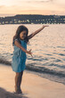 Girl posing on the beach; Little girl posing on the beach in casual clothes, barefoot and doing comical poses