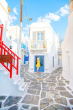 Fototapeta Uliczki - Woman in yellow dress at the Streets of old town Mykonos during a vacation in Greece, Little Venice Mykonos Greece