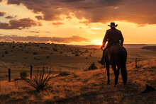 Cowboy Horseman Riding A Horse In Desert Against Mountain Suset Background